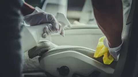 Autositze werden mit einem Reinigungsspray und Tuch gesäubert