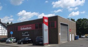 Werkstattgebäude des Autohaus Schaeben mit Parkplätzen und KIA-Beschilderung.